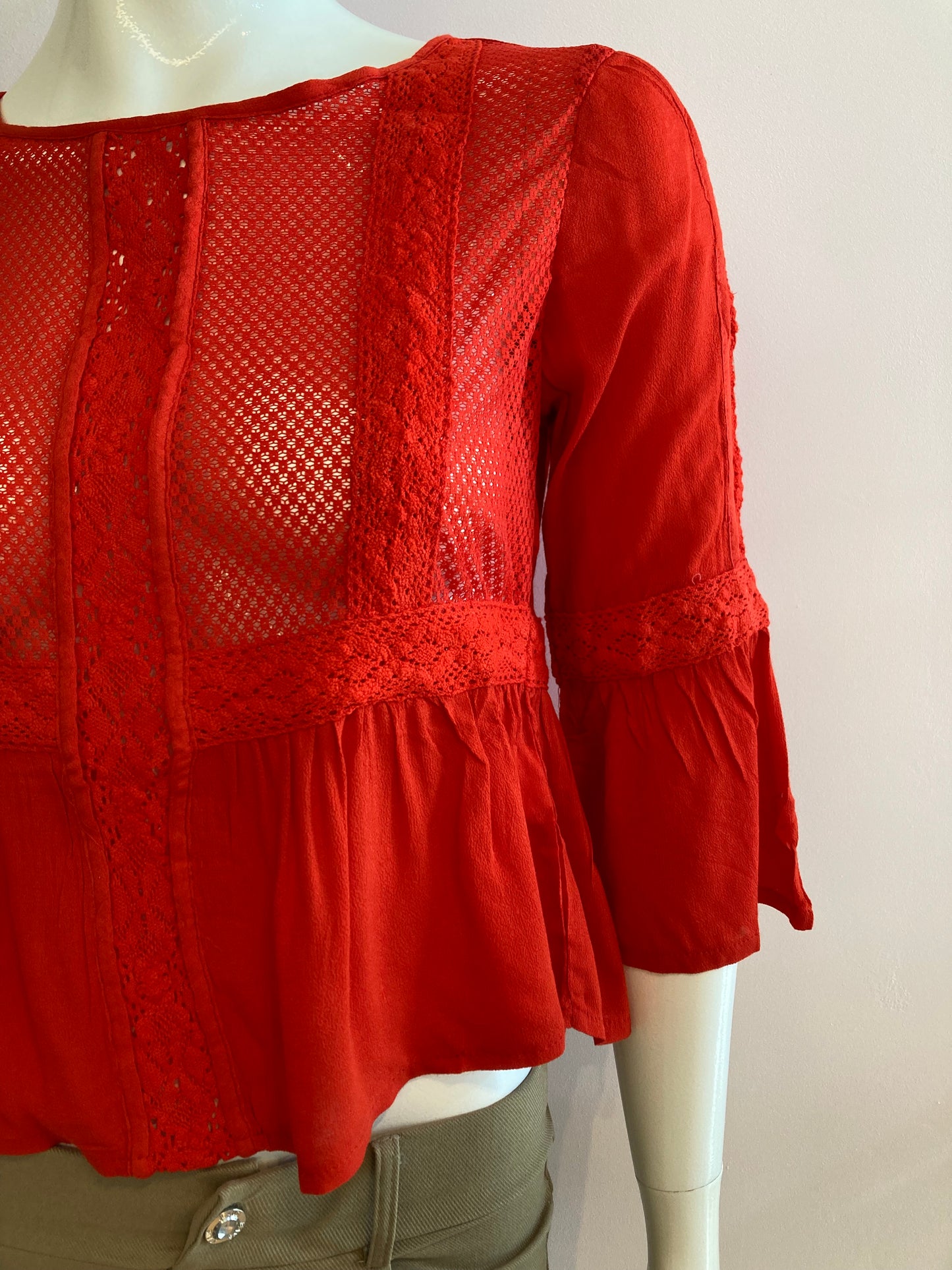 Red blouse with lace on the front and ruffles.