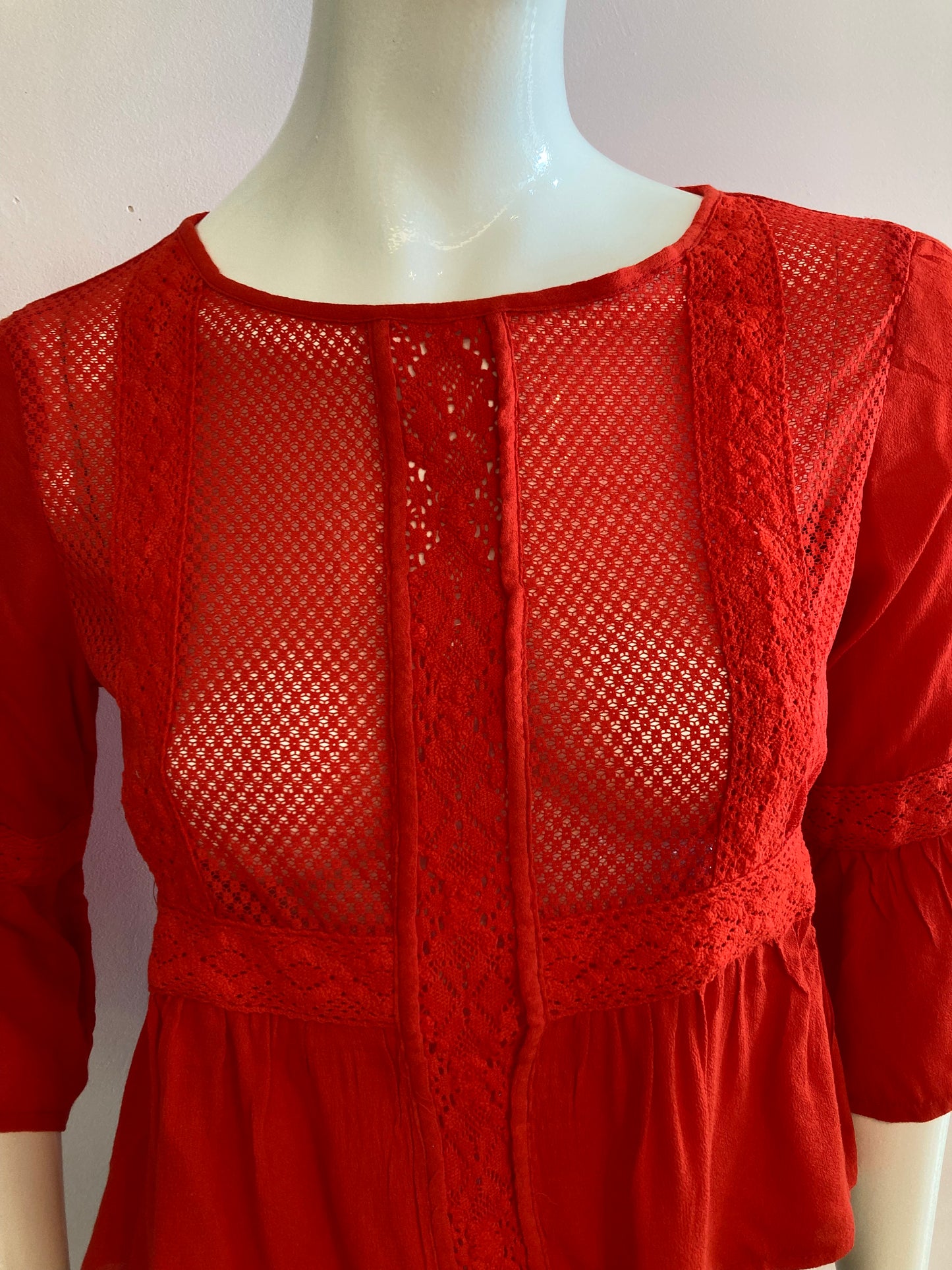 Red blouse with lace on the front and ruffles.