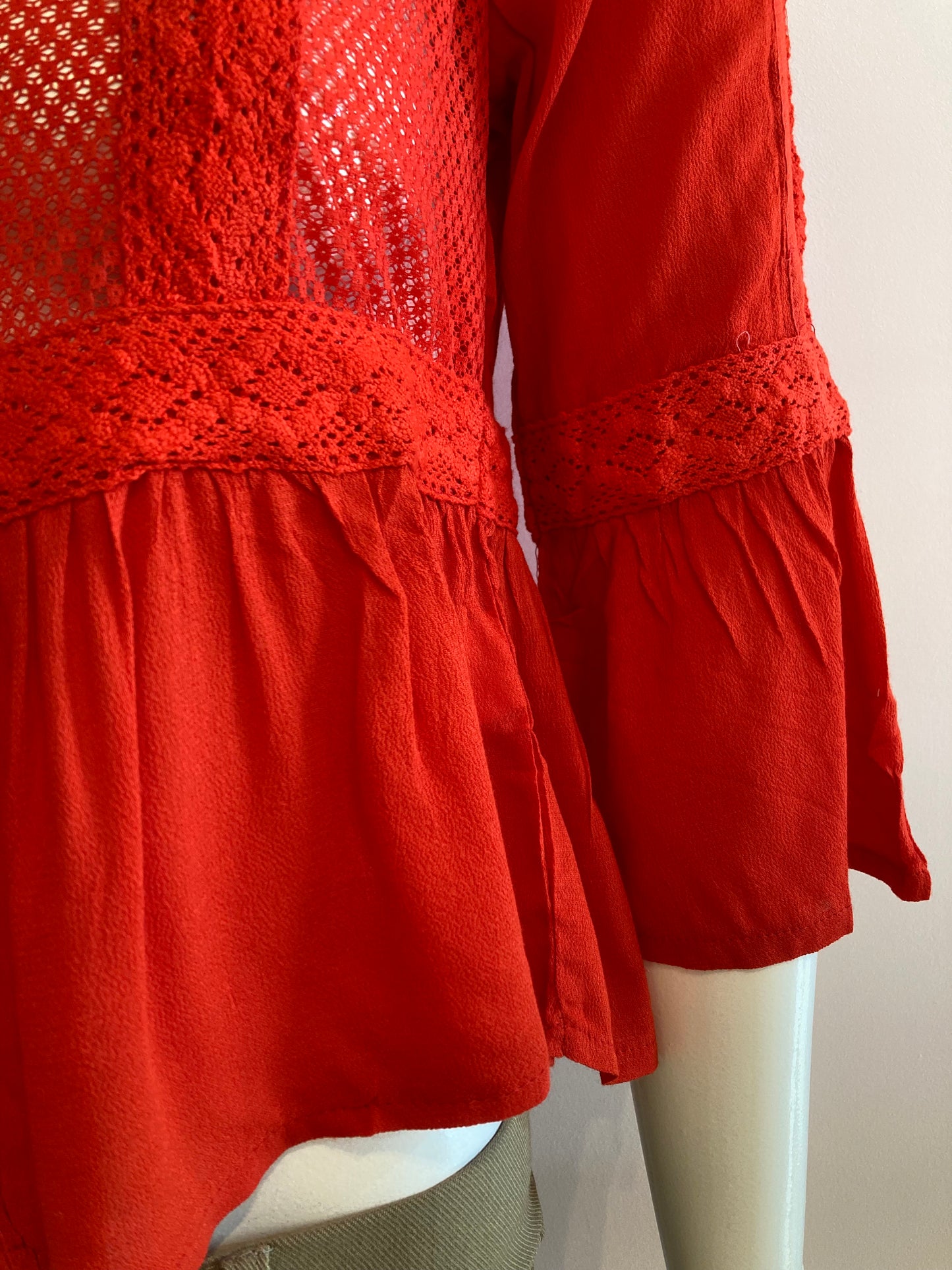 Red blouse with lace on the front and ruffles.