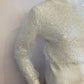 Small ribbed white sweater lined with sequin tulle