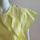 Yellow blouse with ruffle and three buttons on the shoulders