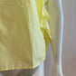 Yellow blouse with ruffle and three buttons on the shoulders