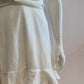 White skater dress with gold and colored yoke on the arms and open back