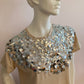 Beige top with large silver sequin on the front