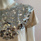 Beige top with large silver sequin on the front