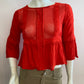 Red blouse with lace on the front and ruffles.