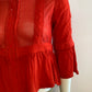 Red blouse with lace on the front and ruffles.