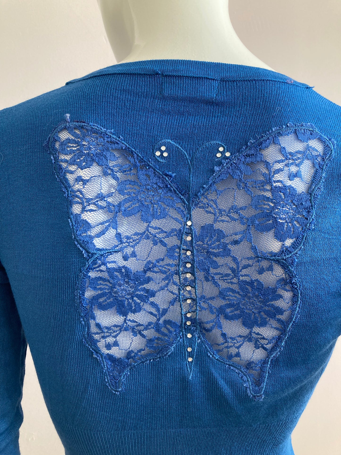 Short cardigan in blue with lace pattern on the back